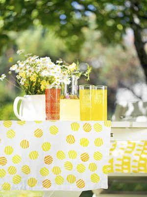 Kuvioiden painaminen kankaalle on helppoa. Pallokuvioinen pöytäliina kuvioitiin itse tehdyllä leimasimella, jonka kuva on jutun lopussa. Pellava Eurokangas, tekstiilivärit Emo, softis-levy Sinelli, juomalasit Astialiisa.