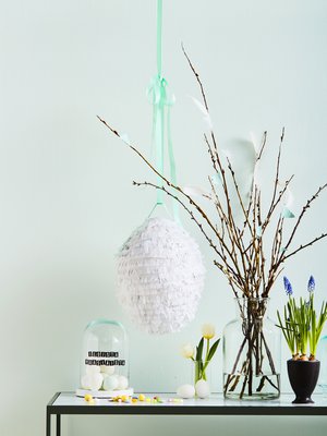 Liimaa pajunvitsoihin sulkia ja paperilippuja, jotka sopivat sävyiltään yhteen pinjatan kanssa. Tarrakirjaimet toivottavat hyvää pääsiäistä. Juhlan jälkeen ne on helppo nappaista pois.