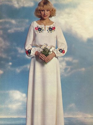 Hele Patjaksen vuonna 1975 suunnittelema yhdistelm&auml;asu sopii k&auml;yt&auml;nn&ouml;lliselle morsiamelle. Asuun kuuluu ruusuilla ja kaunokeilla kirjottu pusero ja kietaisuhame.