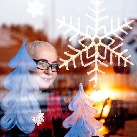 Ikkunaan Sira maalaa lumisen maiseman piimällä. Se tuo joulutunnelmaa, vaikka lunta ei olisikaan.