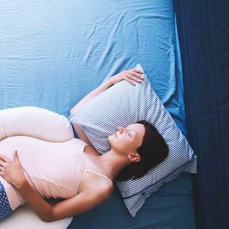 Vartalon mittainen asentotyyny on monelle tuttu raskaus- ja imetysajalta. Kyljellään nukkujan lantio pysyy oikeassa asennossa, kun päällimmäinen jalka on tyynyn päällä.