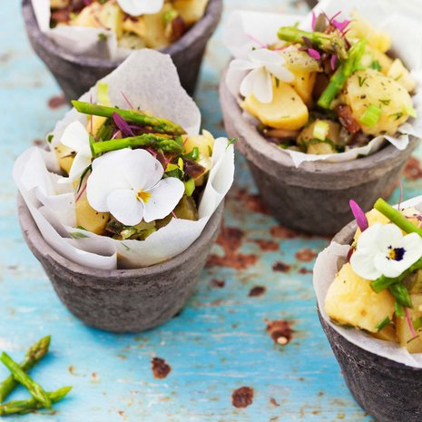Keväinen parsa-perunasalaatti tarjotaan pienistä voipaperilla vuoratuista ruukuista – kukkasenkeveällä koristelulla.