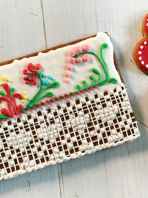 Kiti tekee pitsikuviot pienillä pursottimilla. Paksu pohjaväri tehdään edellispäivänä juoksevammalla kuorrutteella, ja se saa kovettua rauhassa ennen kuvioiden lisäämistä.