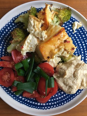 Lautasellinen täydellisiä makuja: paahdettua fetaa ja parsakaalia, hummusta, tomaattia ja sipulinvarsia. Kokeile satsia myös pitaleivän täytteeksi!