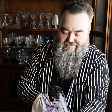 Petri puhdistaa harvinaista lilan väristä Viisas ja tyhmä -maljakkoa. Kaiverrus  on Sulo Tommolan työtä vuodelta 1948.