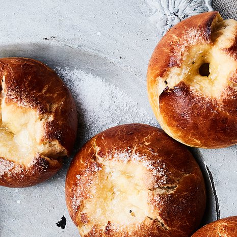 Karamellisoitunut voisilmä katsoo uunituoreista pullista lumoavasti.