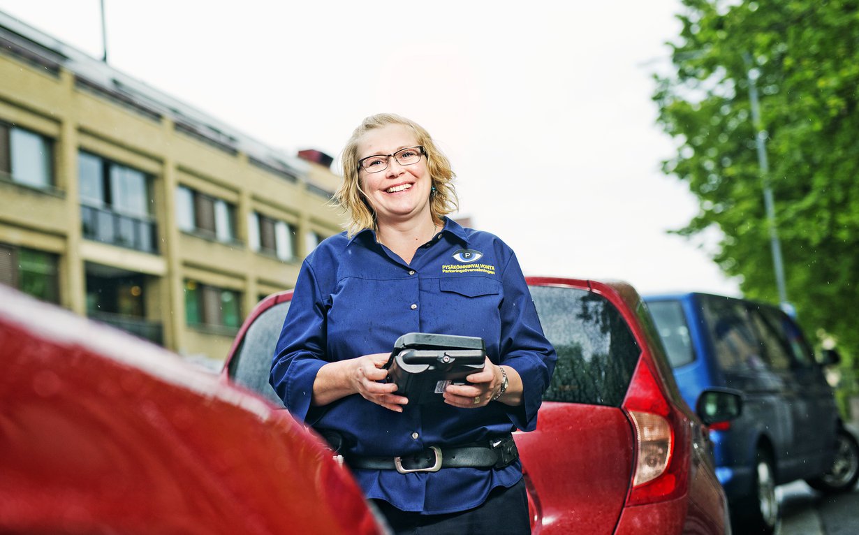 Pysäköinnintarkastaja Tiina Salonen nauttii ulkotyöstä. Työpäivän aikana hän kävelee 15 kilometriä.