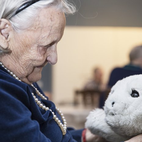Hilkka, 96, on hoitokoti Iltatähden vanhin asukas ja tietää hyvin, ettei Paro ole elävä olento. Silti sitä on mukavaa silitellä. ”Ihan kuin se nauttisi siitä, että rapsutellaan.”