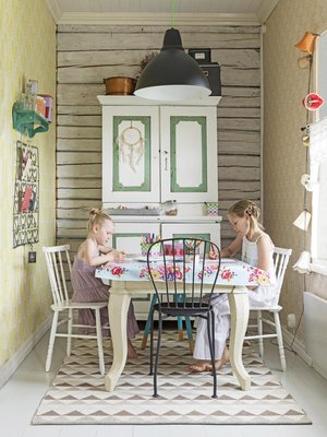 Huldan ja Thelman piirtelyhetki autiotalosta pelastetun pöydän ääressä. Kaappi, jossa säilytetään askartelutarvikkeita, on kirpputorilöytö.