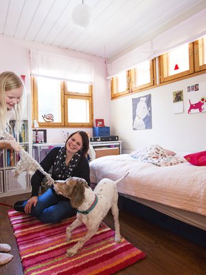 Maria Juntunen muutti tähän huoneeseen 30 vuotta sitten. Nyt siinä asuu hänen esikoisensa Miisa. Sulo-koira viihtyy siellä missä Miisakin.