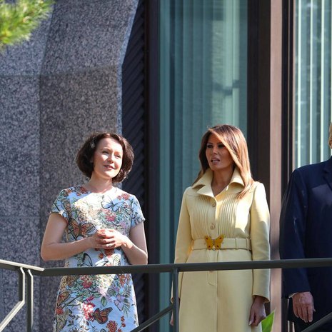 Presidenttien puolisot Jenni Haukio ja Melania Trump Mäntyniemen parvekkeella. Andiata tiedotti ylpeänä, että Jennin asu oli heidän mallistostaan. Helsingin Sanomien mukaan virkasiskon asu oli puolestaan Guccin, perhonen vyön solkena. 