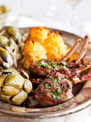 Yrteillä maustetut kyljykset nautiskelevat latva-artisokkien ja perunamuhennoksen seurasta.