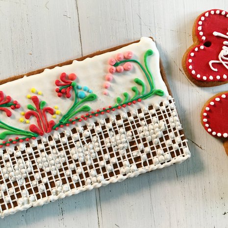 Kiti tekee pitsikuviot pienillä pursottimilla. Paksu pohjaväri tehdään edellispäivänä juoksevammalla kuorrutteella, ja se saa kovettua rauhassa ennen kuvioiden lisäämistä.