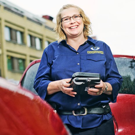 Pysäköinnintarkastaja Tiina Salonen nauttii ulkotyöstä. Työpäivän aikana hän kävelee 15 kilometriä.