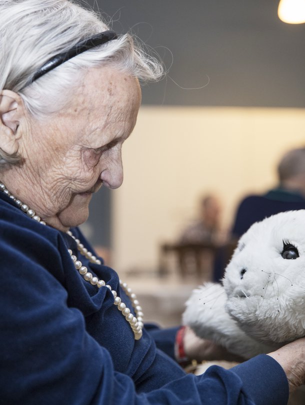 Hilkka, 96, on hoitokoti Iltatähden vanhin asukas ja tietää hyvin, ettei Paro ole elävä olento. Silti sitä on mukavaa silitellä. ”Ihan kuin se nauttisi siitä, että rapsutellaan.”
