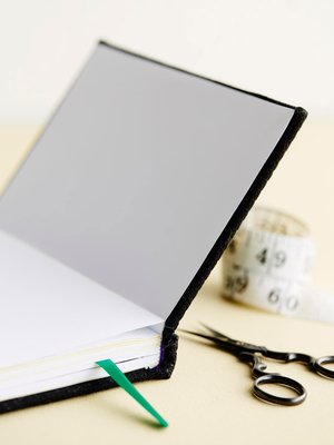 Viimeistele kalenteri liimaamalla ensimmäinen ja viimeinen sivu kansiin. Jos kangas repsottaa kulmien tai selän kohdalta, siis se sivelemällä päälle sormella liimaa.