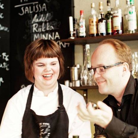 Korkki irti! Tiskin  takana pullon avaaja Ella Mäkelä. Mikko Haakana nuuhkii: viini on kunnossa.