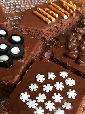 Mokkapalojen tasainen kuorrutus on mahtava pinta erilaisille koristeille. Kuvan mokkapaloissa on käytetty salmiakkitoffeeta, lakupaloja, suolatikkuja, popcornia, suklaarusinoita ja koristerakeita.