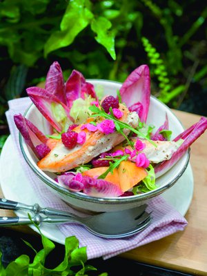 Kirpakka punasikuri kehystää vadelmilla viimeistellyt broilerisalaatin.