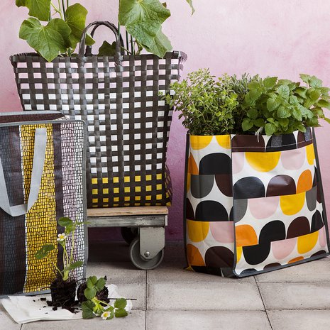 Kauppakasseista saa värikkään ja hauskan "kasvimaan" parvekkeelle. Kun multaa on paljon, kasvit eivät myöskään kuivu nopeasti.